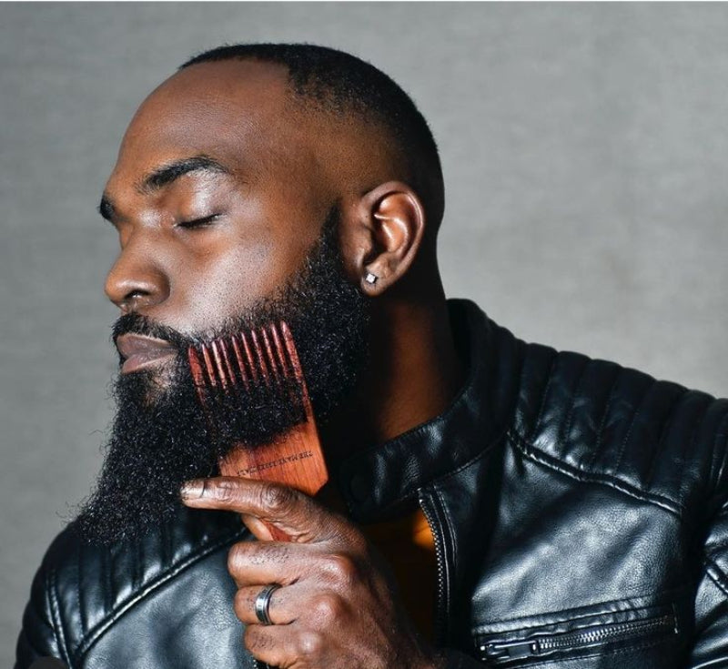 Man combing out his groomed beard.